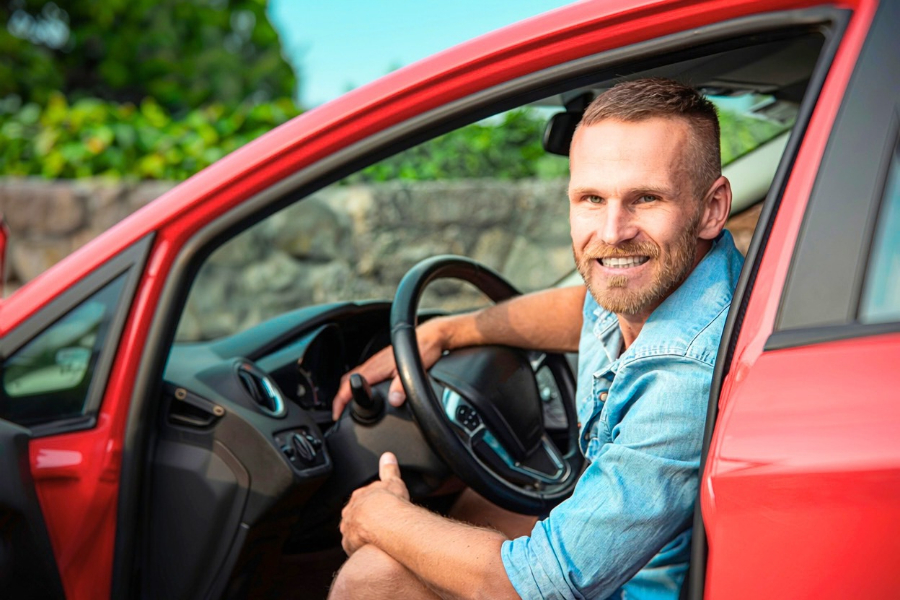 Man Driving a Red Car
