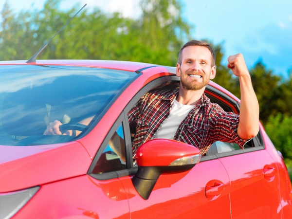 Man Driving a Red Car